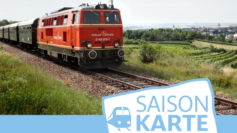 Saisonkarte Reblaus Express, © NÖVOG/Weinfranz Ein roter Zug fährt durch eine ländliche Landschaft mit Feldern und einem Dorf im Hintergrund. Unten rechts ist das Logo 'Saisonkarte' zu sehen.