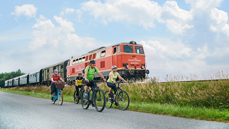 Radfahrer fahren neben Reblaus Express