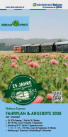 Roter Zug mit mehreren Waggons fährt durch eine grüne Landschaft mit rosa Blumen im Vordergrund und Hügeln im Hintergrund.