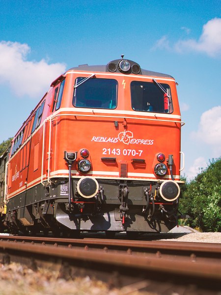 Rote Diesellokomotive mit Reblaus Express Logo