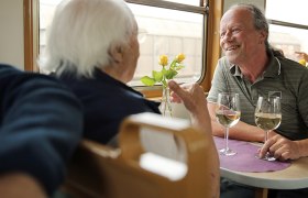 zwei Herren sitzen zusammen und genießen Wein